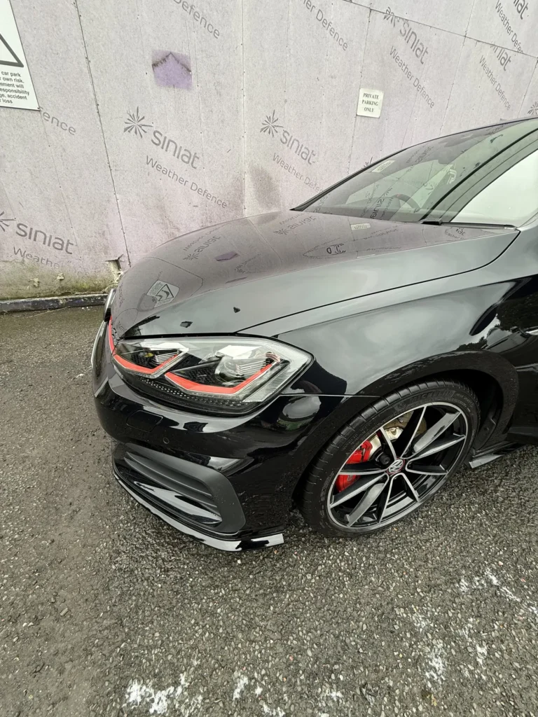 Black Volkswagen Golf GTI TCR viewed from the front with red grille trim