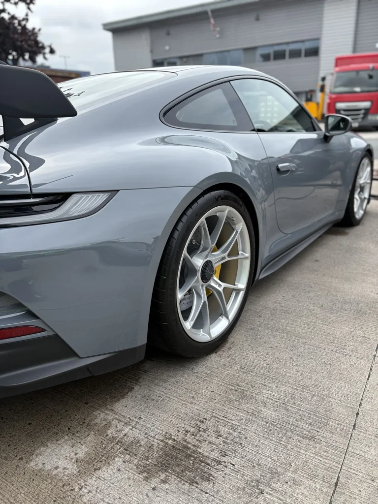 Grey Porsche with a fixed rear wing, silver wheels and yellow brake calipers