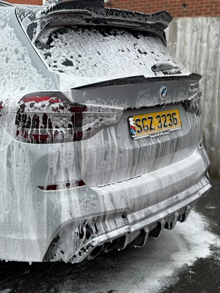 White BMW X3 M covered in wash foam